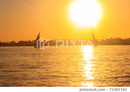 View of the Nile river with sailboats at sunset in Luxor, Egypt 71465392