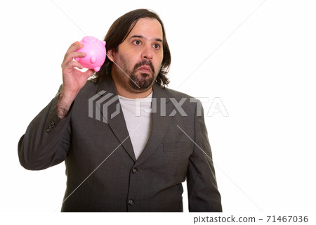 Fat Caucasian businessman thinking and shaking piggy bank 71467036