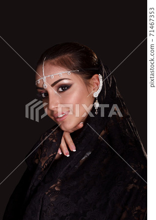 Pretty oriental woman in abaya on black background Pretty oriental woman in abaya on black background 71467353