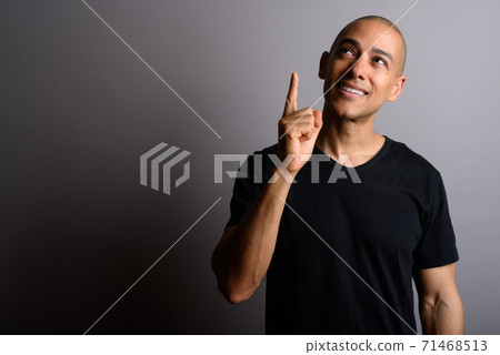 Handsome bald man thinking and pointing finger up Handsome bald man thinking and pointing finger up 71468513