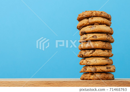 Stack of chocolate chip cookies against blue background Stack of chocolate chip cookies against blue background 71468763