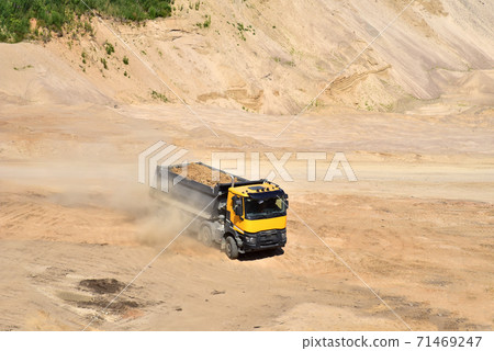 Dump truck transports sand in open pit mine 71469247