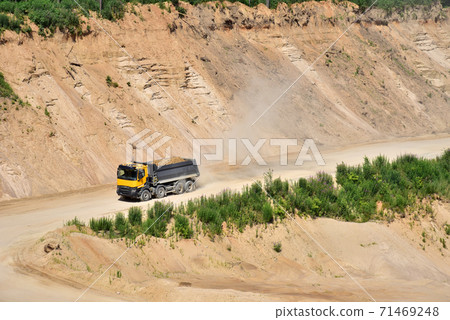 Dump truck transports sand in open pit mine.  71469248