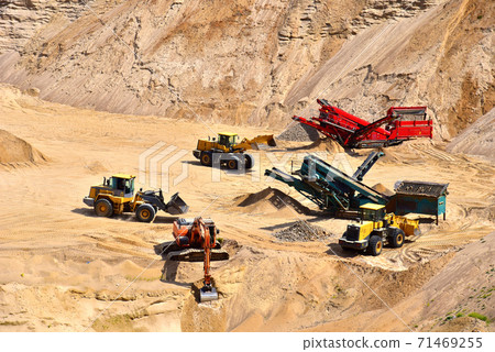 Wheel front-end loader loads sand into a dump truck. Heavy machinery in the mining quarry 71469255