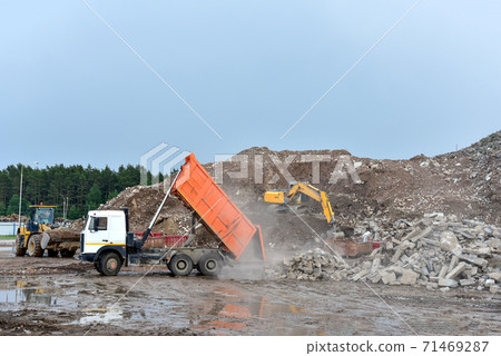Dump truck unloading old concrete and asphalt from demolition for recycling. Dump truck unloading old concrete and asphalt from demolition for recycling. 71469287