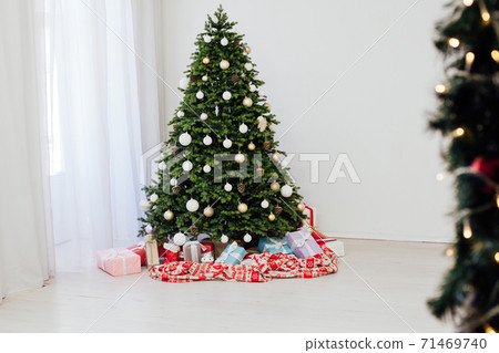 Winter Christmas tree pine with gifts new year decor garland interior of the holiday home December 71469740
