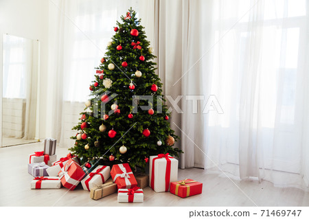 Winter Christmas tree pine with gifts new year decor garland interior of the holiday home December 71469747