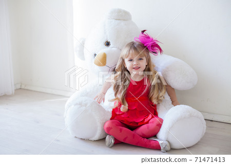 Beautiful little girl holding a white teddy bear toy 71471413