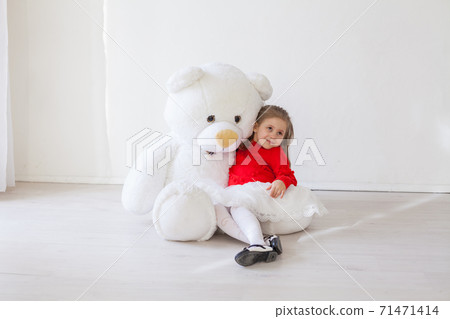 Beautiful little girl holding a white teddy bear toy 71471414