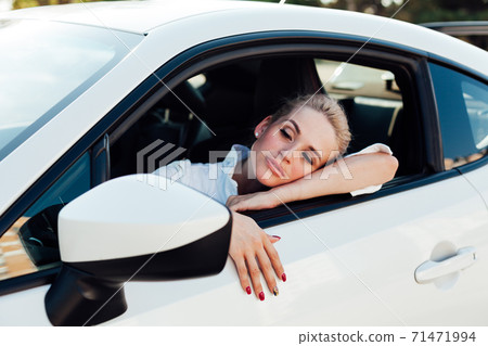 Beautiful female blonde driver behind the wheel of a car on the road Beautiful female blonde driver behind the wheel of a car on the road 71471994