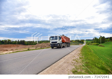 Truck with tipper semi trailer transported sand from the quarry on driving along highway. 71472041
