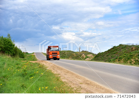 Tipper Dump Truck transported sand from the quarry on driving along highway. Modern Heavy Dump Truck 71472043
