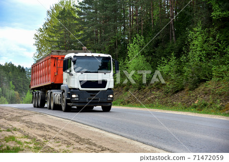 Truck with tipper semi trailer transported sand from the quarry on driving along highway. 71472059