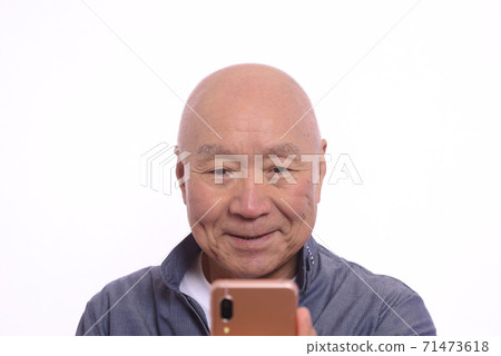 帶著微笑操作智能手機的日本老人 71473618