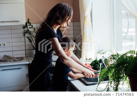 beautiful mom and son wash fresh vegetables 71474563