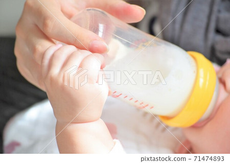 母親的手喝牛奶,嬰兒的小可愛手握住那隻手 母親的手喝牛奶,嬰兒的小可愛手握住那隻手 71474893