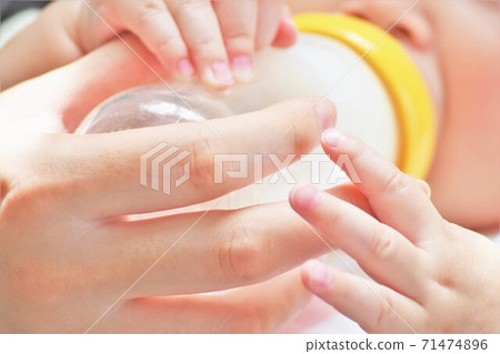 母親的手喝牛奶，嬰兒的小可愛手握住那隻手 71474896