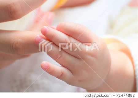 母親的手喝牛奶,嬰兒的小可愛手握住那隻手 母親的手喝牛奶,嬰兒的小可愛手握住那隻手 71474898