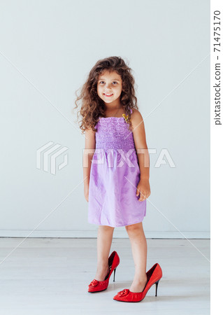 Beautiful fashionable little girl in a dress and mom's shoes 71475170