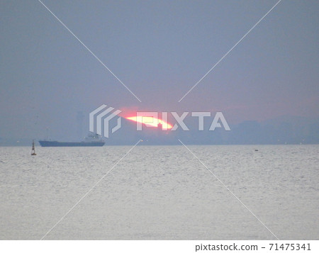 A momentary glow of the setting sun between the clouds over Tokyo Bay 71475341