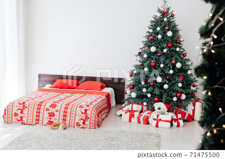 Christmas tree in the interior of the bedroom with a bed and pads for the new year 71475500