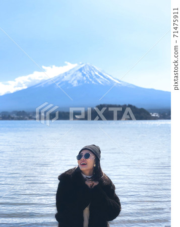 woman tourists are traveling feel happy with Mt Fuji in the morning on the lake kawaguchiko, Japan woman tourists are traveling feel happy with Mt Fuji in the morning on the lake kawaguchiko, Japan 71475911