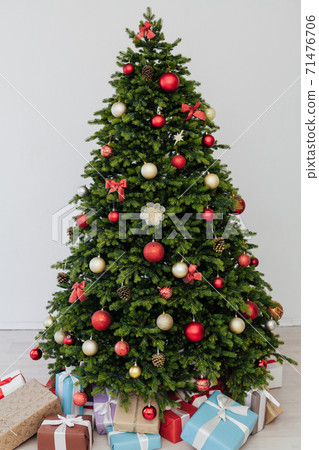 The interior of the room is a green Christmas tree with red gifts for the new year decor of the winter holiday home The interior of the room is a green Christmas tree with red gifts for the new year decor of the winter holiday home 71476706