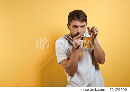 Man with a mug of beer on a yellow background white t-shirt emotions Copy Space Man with a mug of beer on a yellow background white t-shirt emotions Copy Space 71476709
