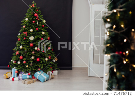 The interior of the room is a green Christmas tree with red gifts for the new year decor of the winter holiday home 71476712