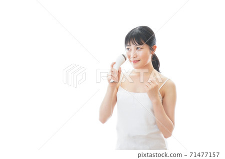 Young woman using beauty equipment Young woman using beauty equipment 71477157