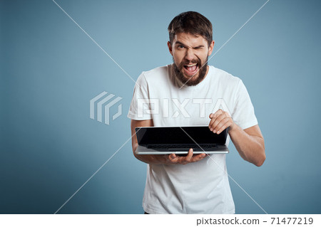 Man shows open laptop keyboard monitor emotions model blue advertising background Copy Space 71477219