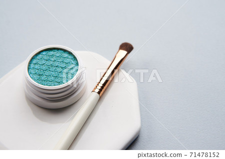 Green eyeshadow and makeup brush on white stand isolated background 71478152