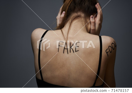 Woman with inscriptions on the body frustration and dissatisfaction emotions lifestyle gray background 71478157