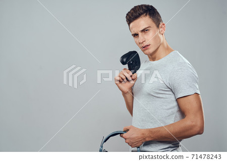 Man with headphones and joystick in hands technology entertainment video games lifestyle addiction light background 71478243