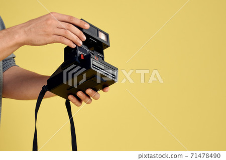 Photo camera in the hands of a man professional equipment hobby Creative approach studio cropped view Photo camera in the hands of a man professional equipment hobby Creative approach studio cropped view 71478490