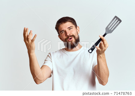 man with cooking shovel and white t-shirt close-up cropped view emotion gesturing with hand man with cooking shovel and white t-shirt close-up cropped view emotion gesturing with hand 71478763
