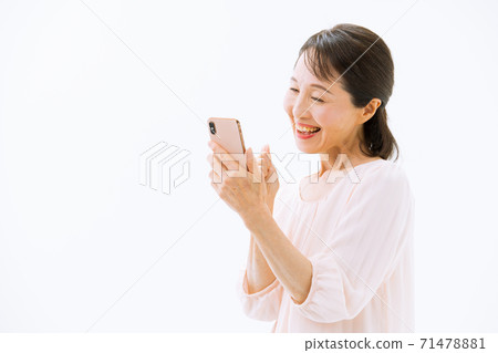 Senior woman with a smartphone smiles Senior woman with a smartphone smiles 71478881