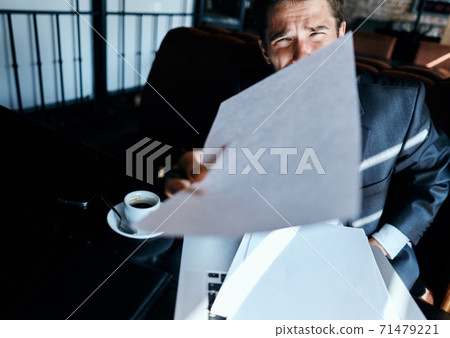Business man in a cafe suit in front of laptop emotions official documents technology Business man in a cafe suit in front of laptop emotions official documents technology 71479221