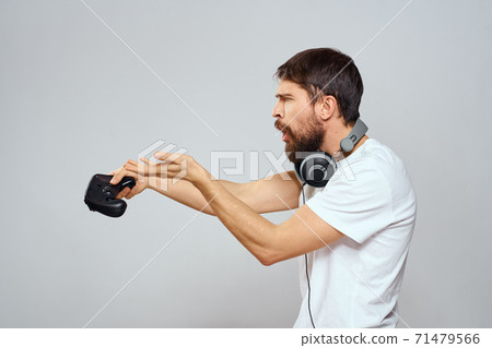Man with gamepad headphones playing leisure technology white t-shirt light background 71479566