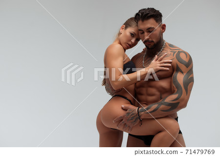 Muscular man hugging topless woman Muscular man hugging topless woman 71479769