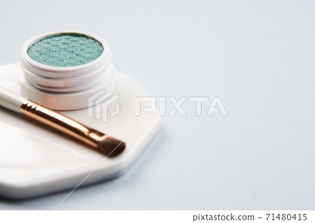 Green eyeshadow and makeup brush on white stand isolated background Green eyeshadow and makeup brush on white stand isolated background 71480415