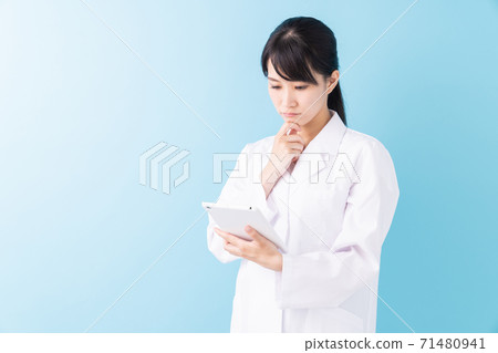 Thinking woman tablet in white coat Thinking woman tablet in white coat 71480941
