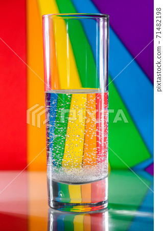 glass of water on background of piece of paper colored LGBT flag 71482198