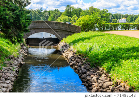 Stone arch bridge across a small river in Catherine park in Pushkin (Tsarskoye Selo), Russia 71485148