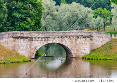 Stone arch bridge across a lake in Gatchina, Russia 71485169