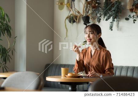 在一家咖啡館吃的可愛女人 在一家咖啡館吃的可愛女人 71486423