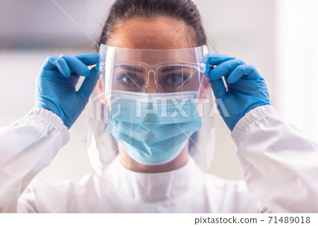 Female medic puts on protective shield and other equipment not get infected by coronavirus Female medic puts on protective shield and other equipment not get infected by coronavirus 71489018