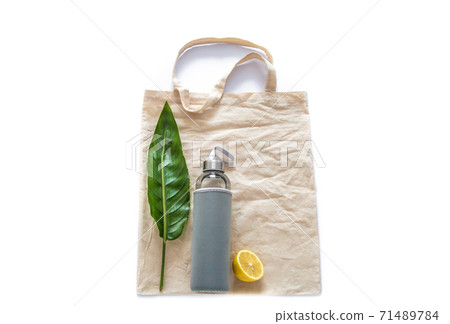 Cotton bag with water bottle fruits raw lemons green leaf on white background flat lay. Zero waste reusable eco friendly materials plastic free Cotton bag with water bottle fruits raw lemons green leaf on white background flat lay. Zero waste reusable eco friendly materials plastic free 71489784
