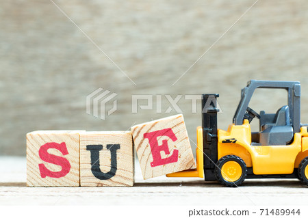 Toy forklift hold letter block e to complete word sue on wood background 71489944