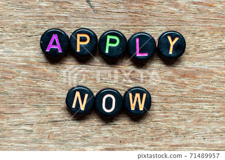 Black bead with color letter in word apply now on wood background Black bead with color letter in word apply now on wood background 71489957